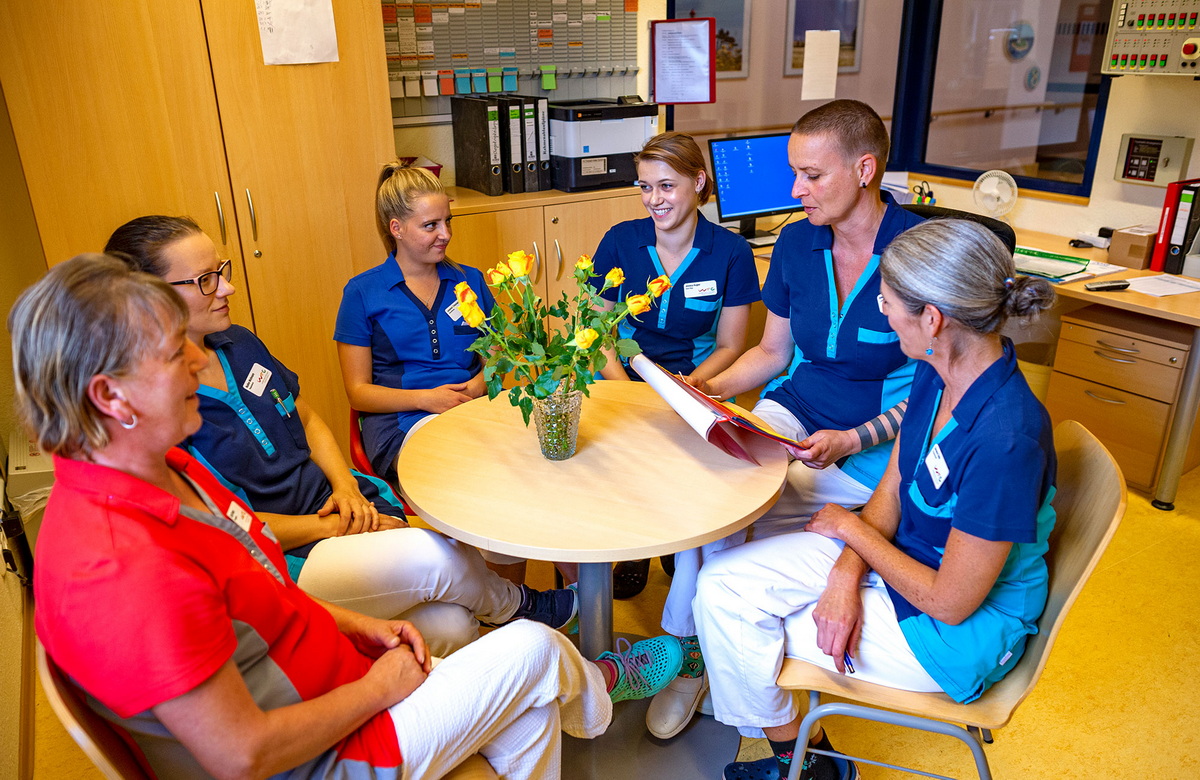 Pflegekräfte sitzen zusammen am Tisch